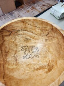wooden bowl with engraving that says "stir up some love"