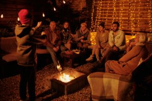group of friends playing charades outside by a fire at night