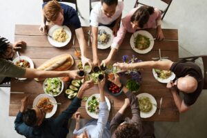 friends toast each other at a sustainable-themed dinner party
