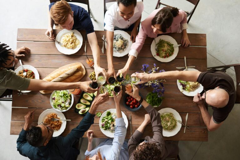 friends toast each other at a sustainable-themed dinner party