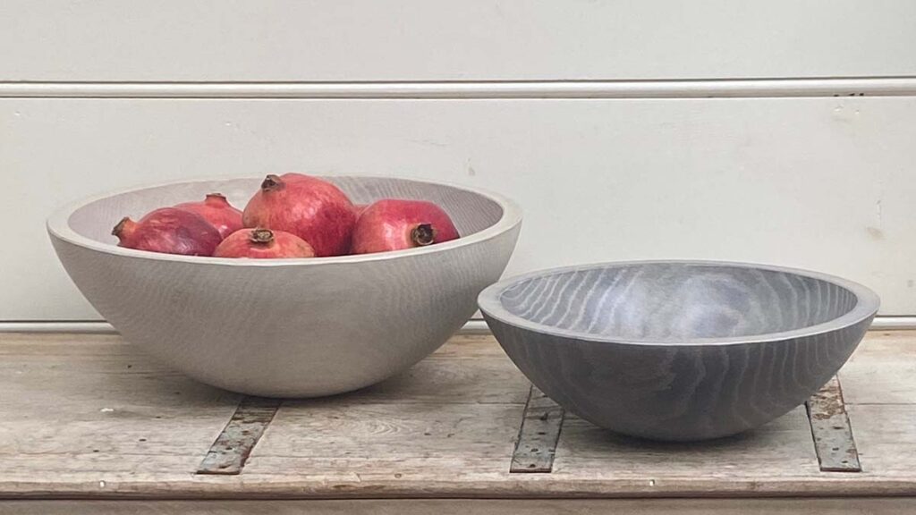 White Pearl and driftwood bowls by Spencer Peterman displayed on an antique cabinet